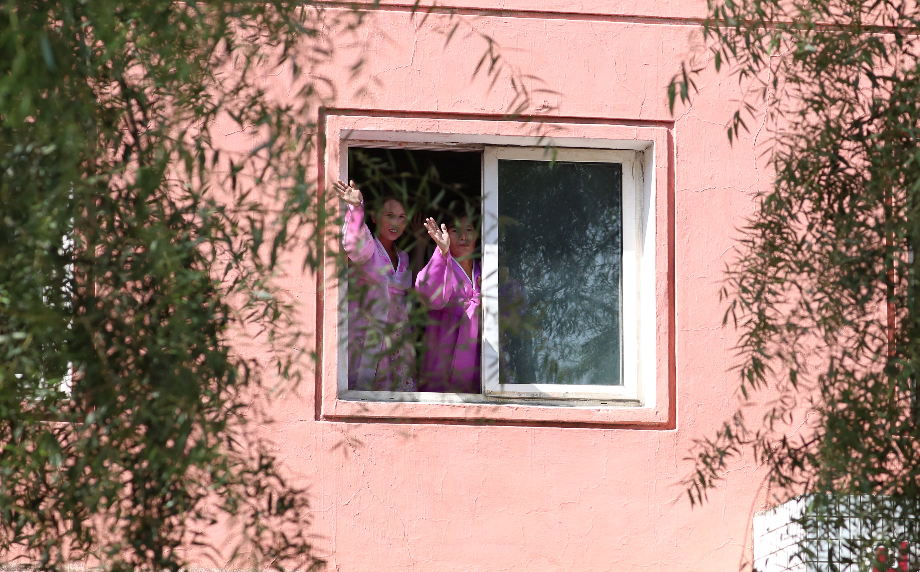 سيدتان يحيان زعيما الكوريتين من أحد نوافذ منزلهما