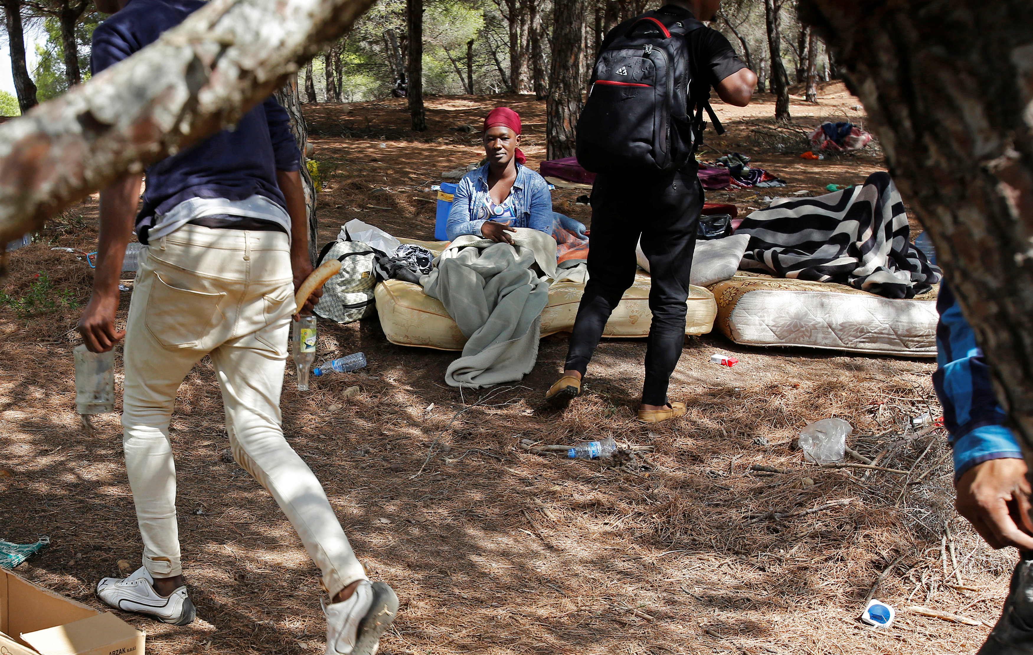أحد أسر المهاجرين يمكثون على الأرض بأحد الغابات