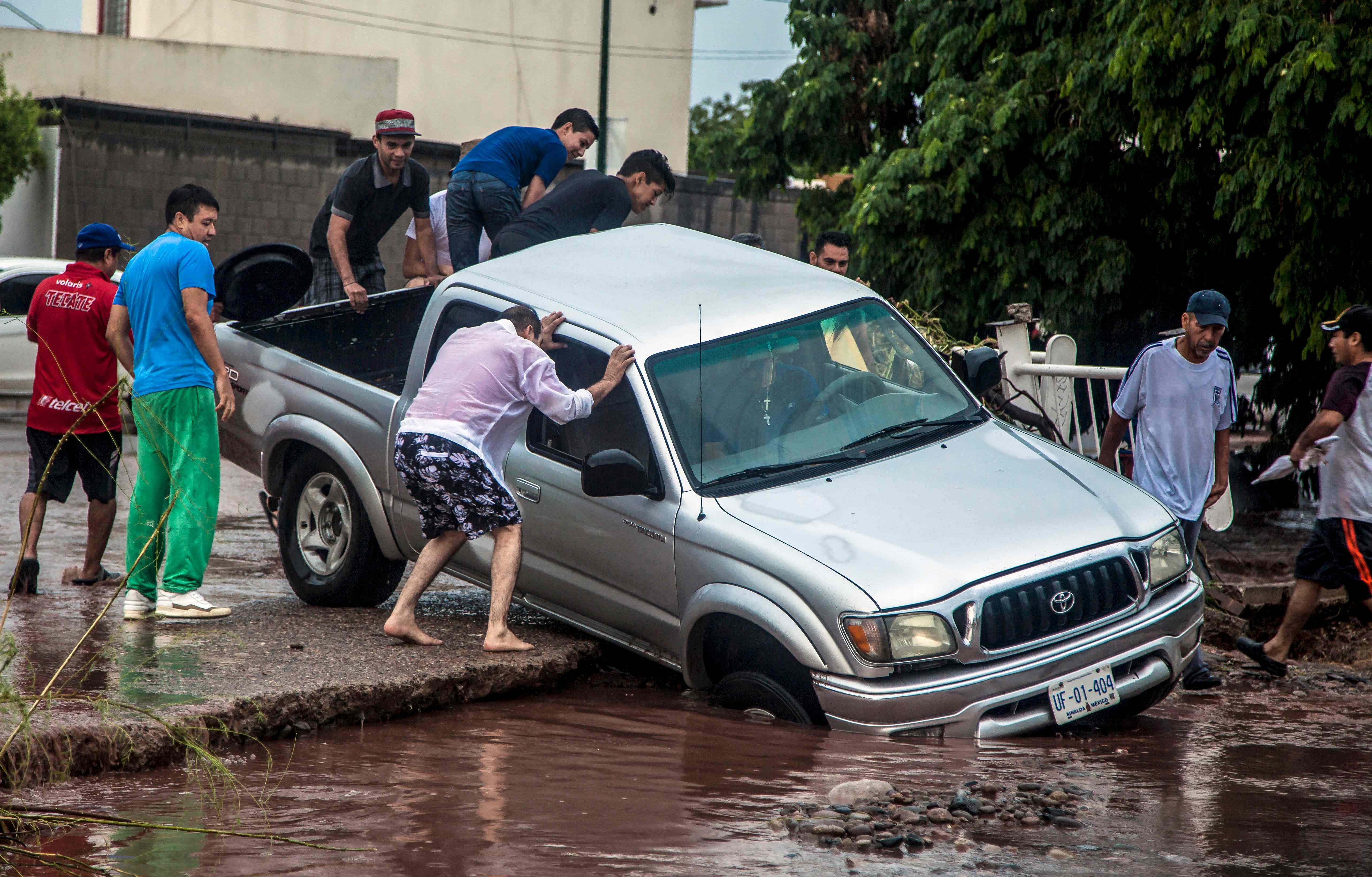  مواطنون مكسيكون يحاولون إنقاذ سيارة من الغرق 