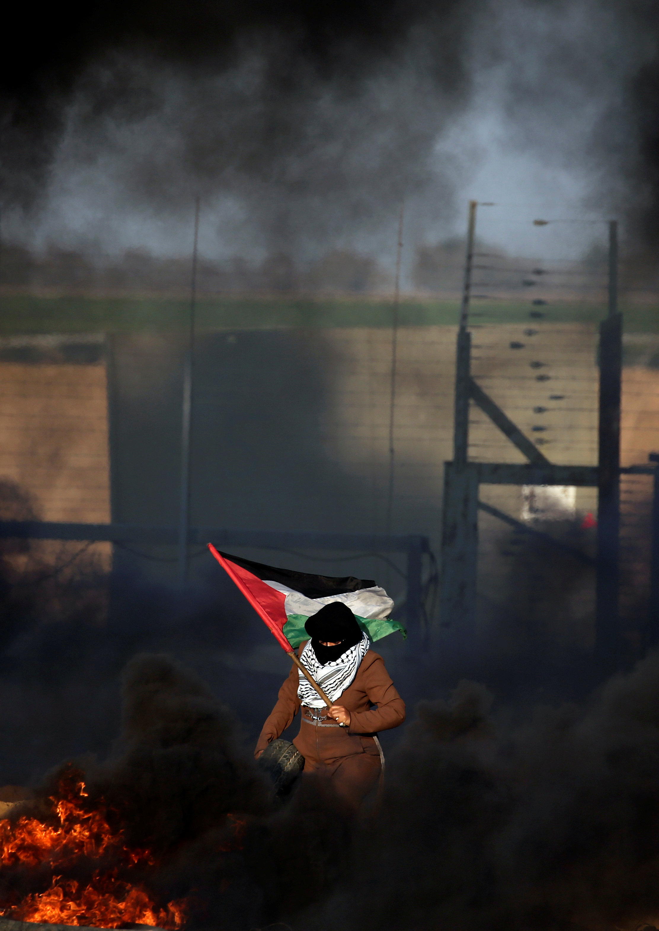 امرأة تحمل العلم الفلسطيني فى احتجاج على السياج الحدودى بين إسرائيل وغزة