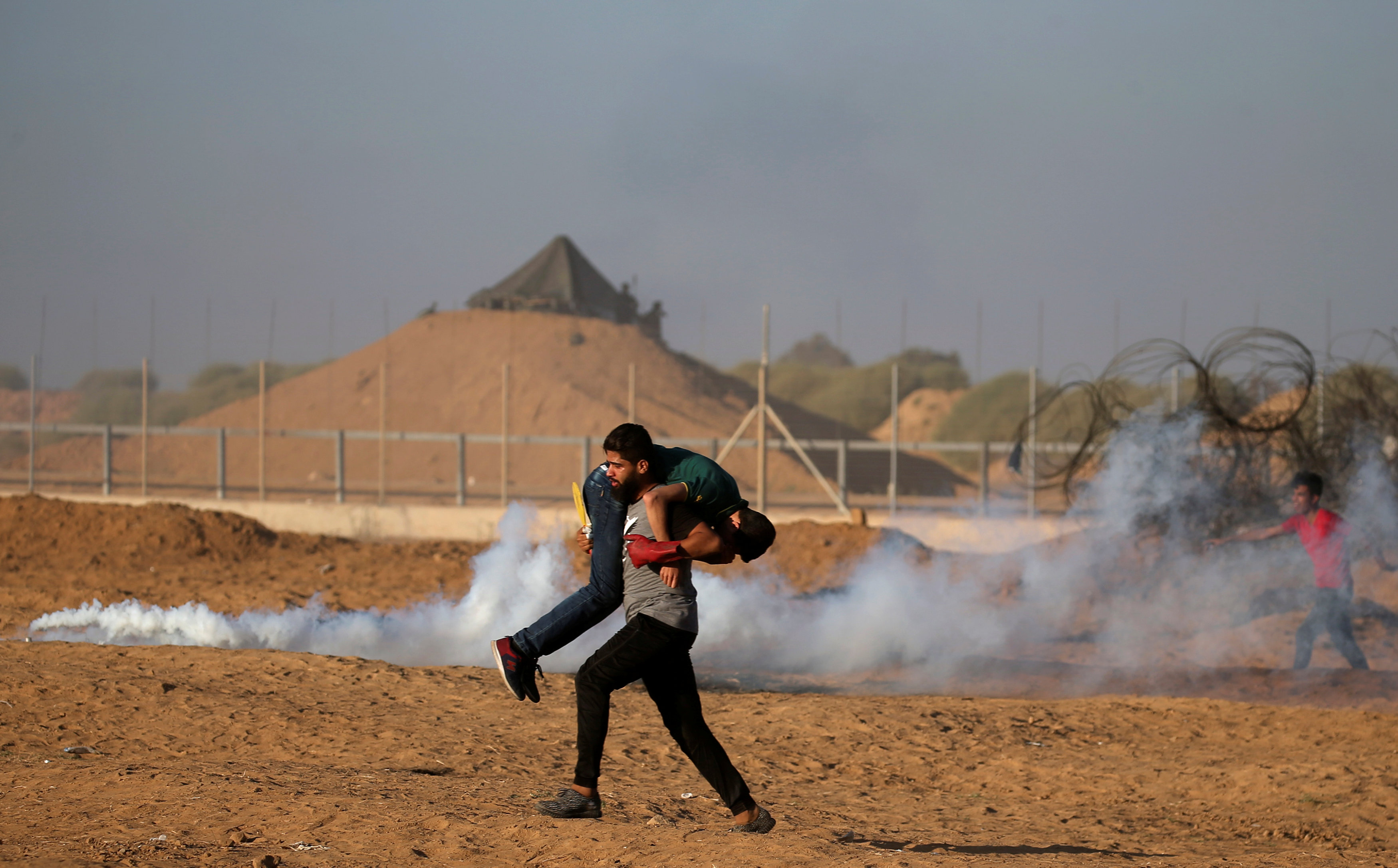 إجلاء جريح فلسطينى خلال مظاهرة فى السياج الحدودى بين إسرائيل وغزة