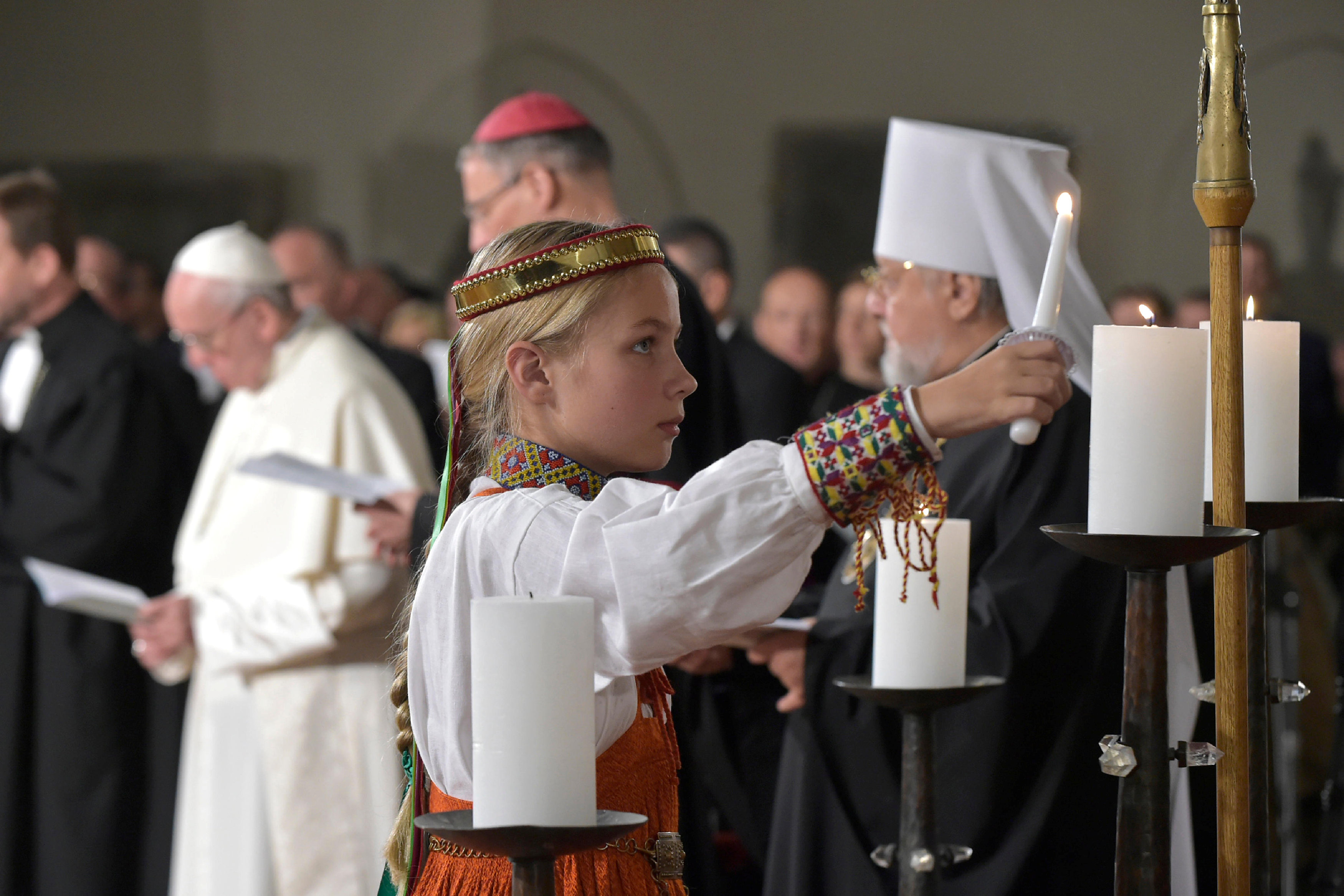 طفلة تشعل شمعه اثناء صلاة البابا