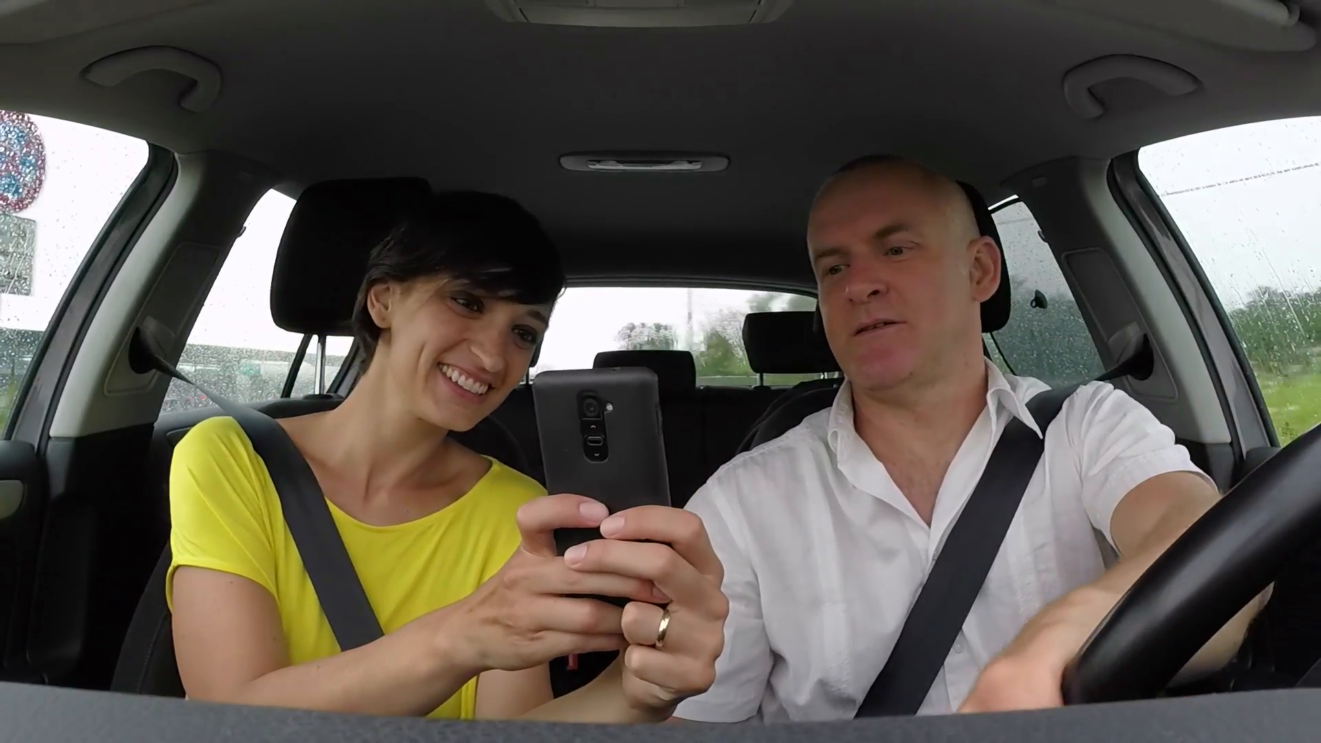 married-white-couple-on-road-trip-happy-people-traveling-by-car-on-the-street-man-driving-vehicle-with-woman-cheerful-husband-and-wife-playing-pokemon-go-with-smartphone_savvhkdo__F0008