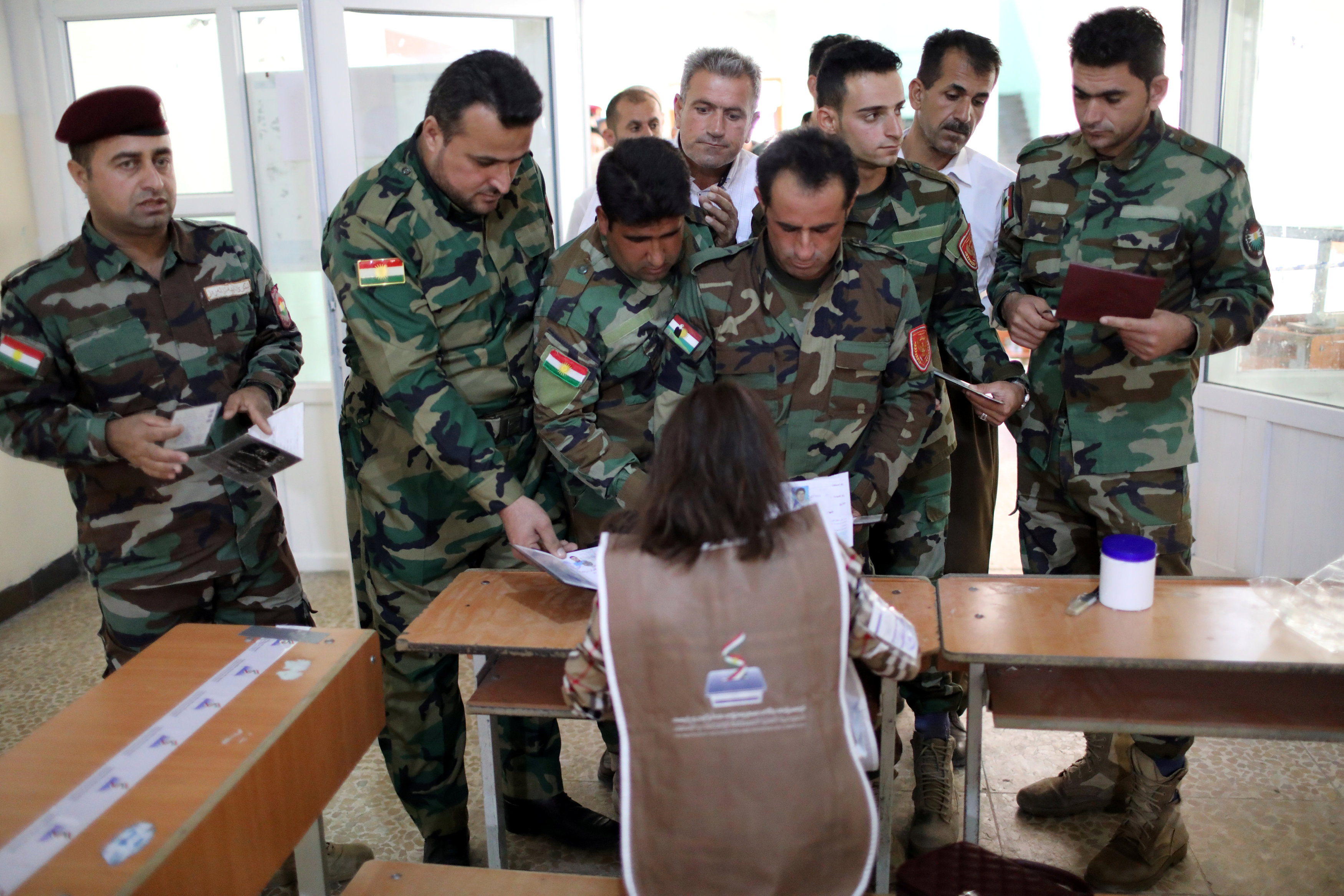 أفراد من القوات العسكرية الكردية يصطفون داخل مركز اقتراع للتصويت فى الانتخابات البرلمانية