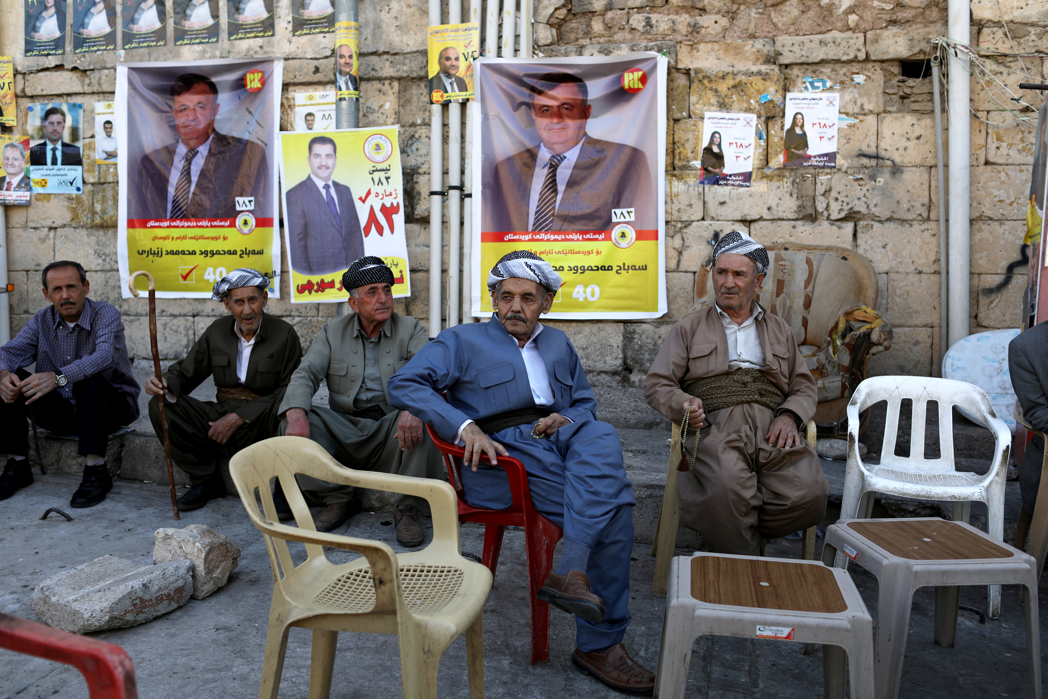 يجلس الأكراد في الشارع في بلدة أكرا
