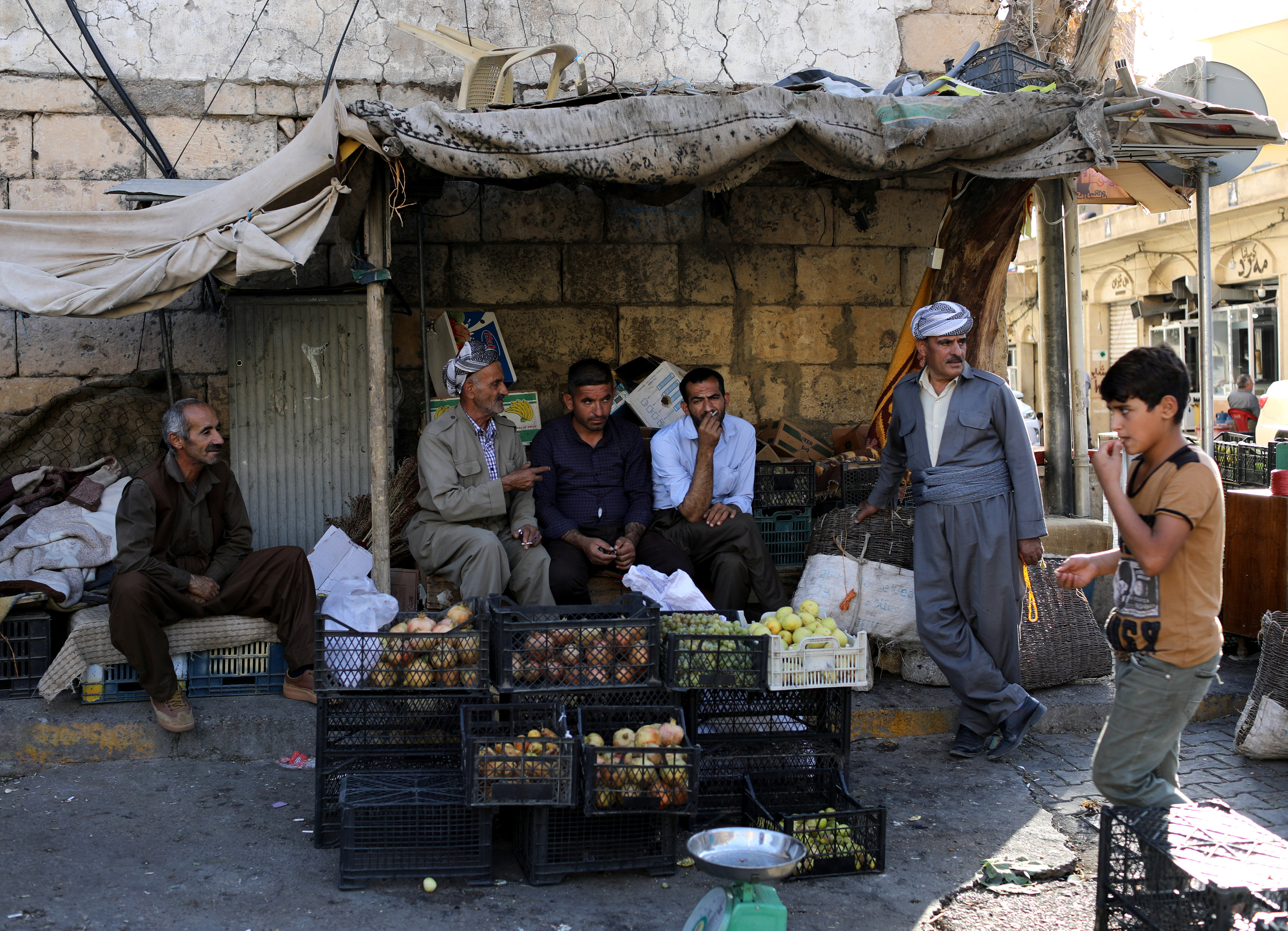 الأكراد يجلسون في أحد شوارع سوق مدينة أكرا