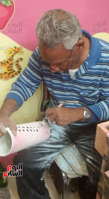    الفنان محمد الشولي خلال صناعة التحف اليدوية بالاقصر