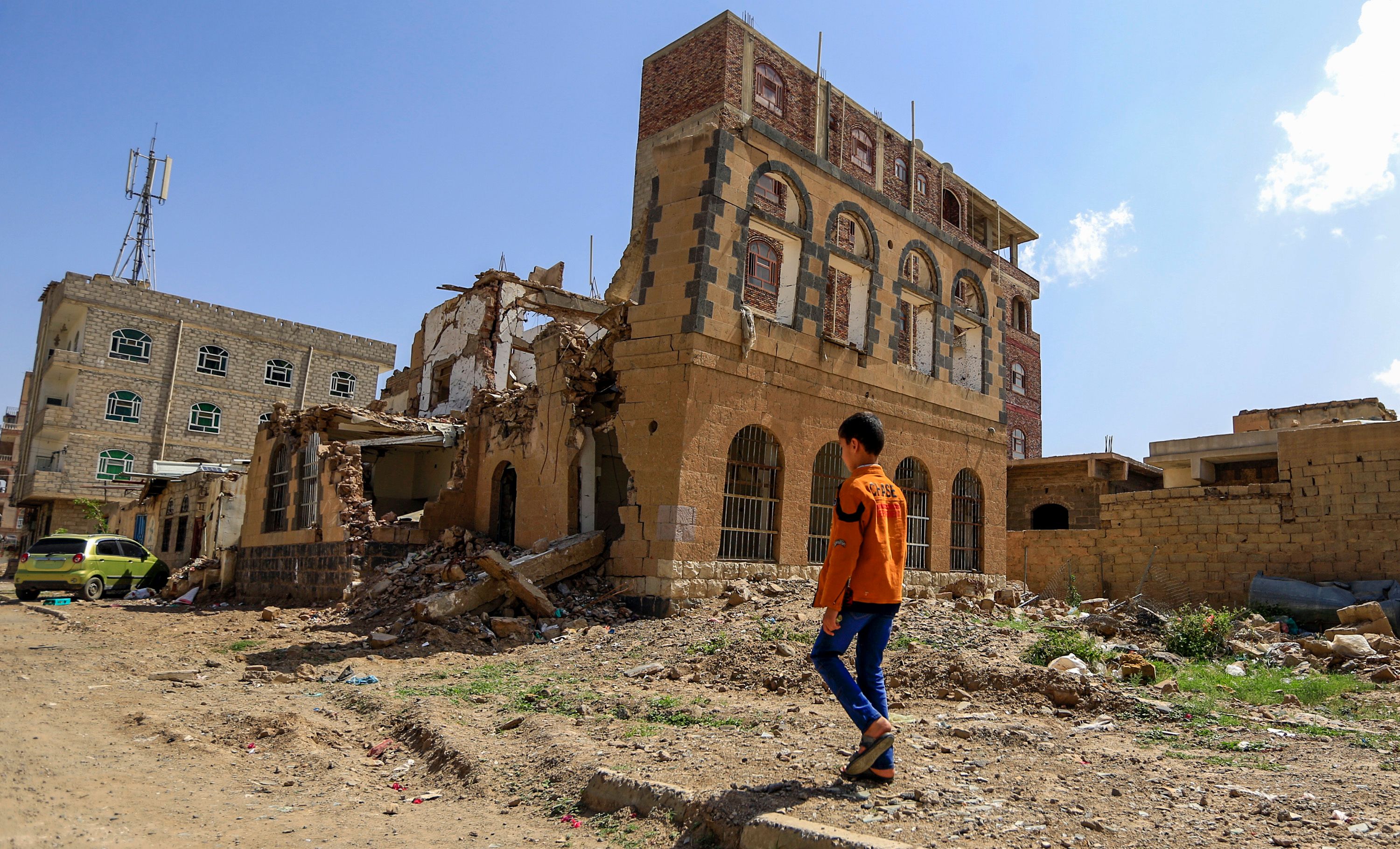 طفل يمنى يمشى باتجاه مبنى تم تدميره فى غارة جوية