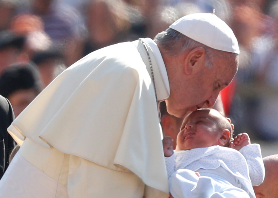 البابا فرنسيس يقبل طفلا قبل حديثه للجمهور العام