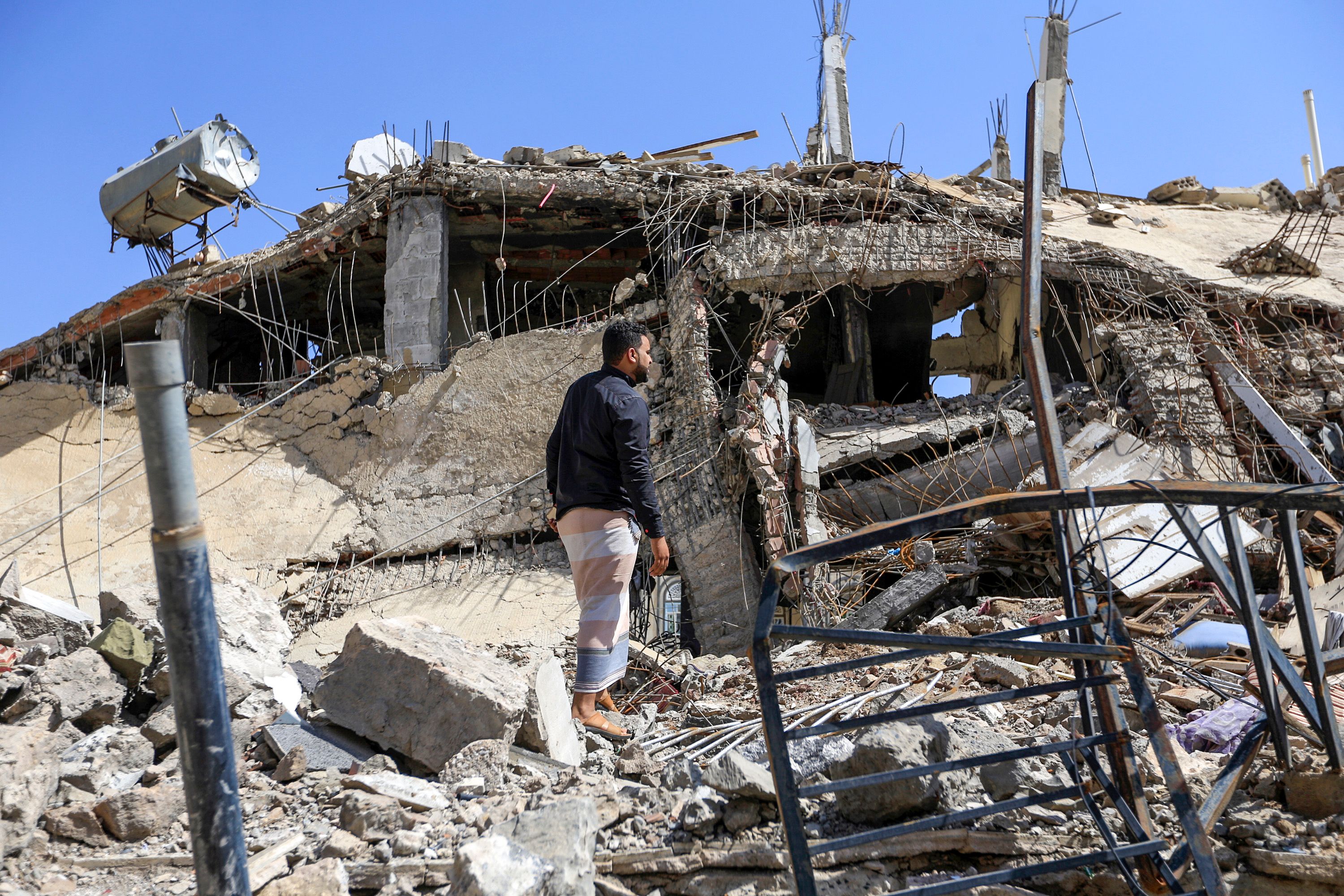 رجل يمنى يشاهد مبنى تم تدميره فى غارة جوية