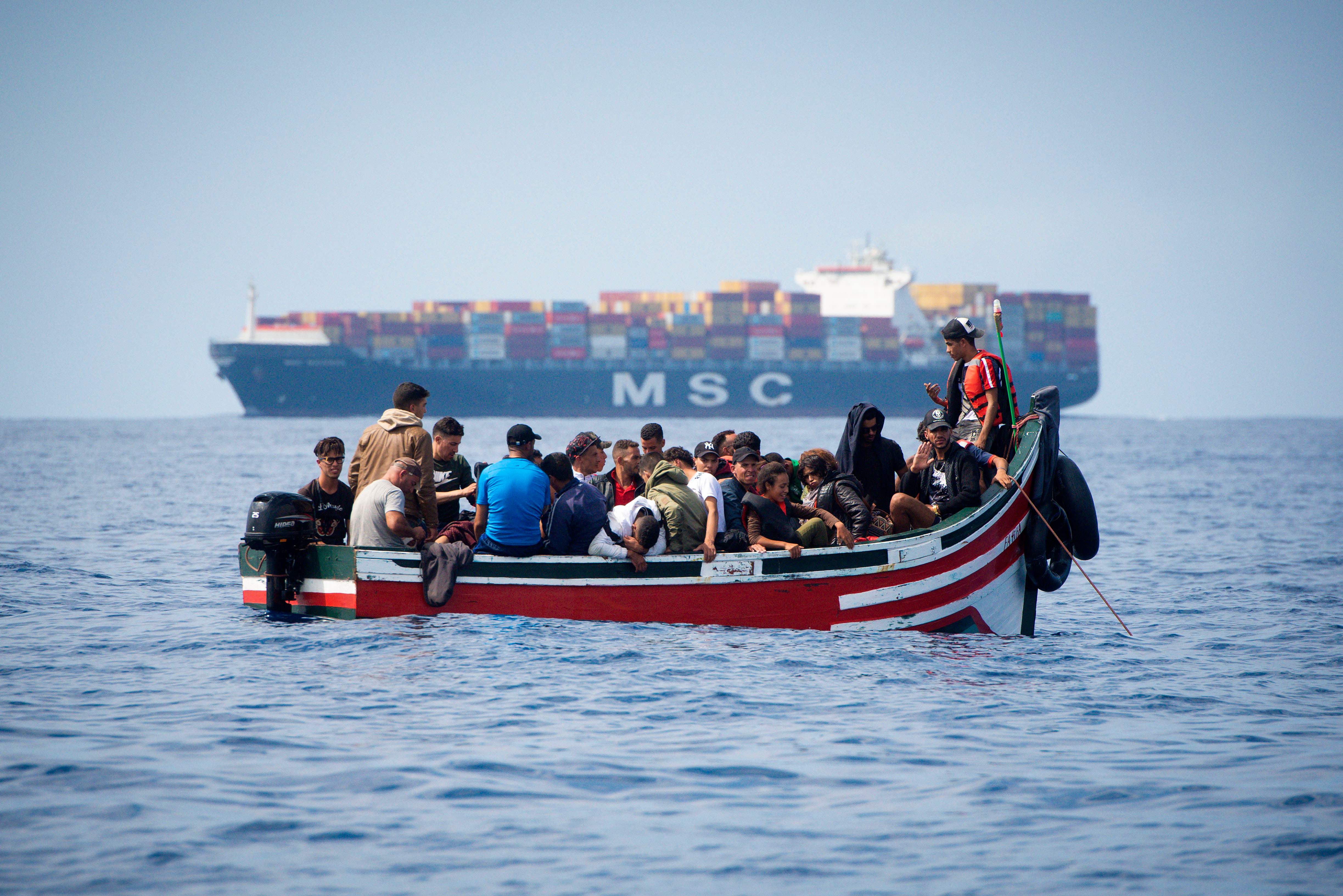 قارب المهاجرين بالقرب من احدى السفن التجارية 