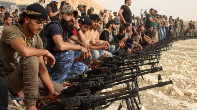 مقاتلو معارضة سوريون يجلسون خلف رشاشات اسرائيلية بدرعا،