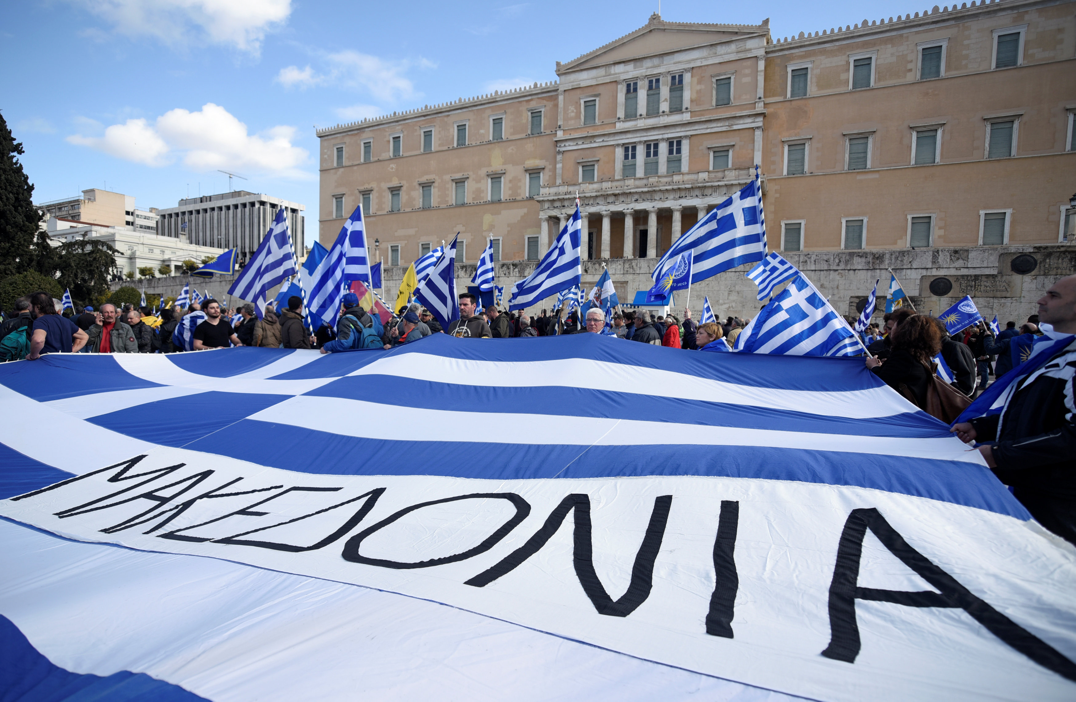 المتظاهرون يرفعون أعلام اليونان