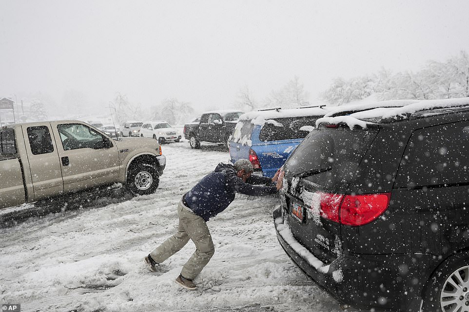 رجل يحاول أن يخرج سيارته من وسط الثلوج فى ولاية يوتا