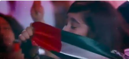 الطفلة سارة تقبل علم الإمارات