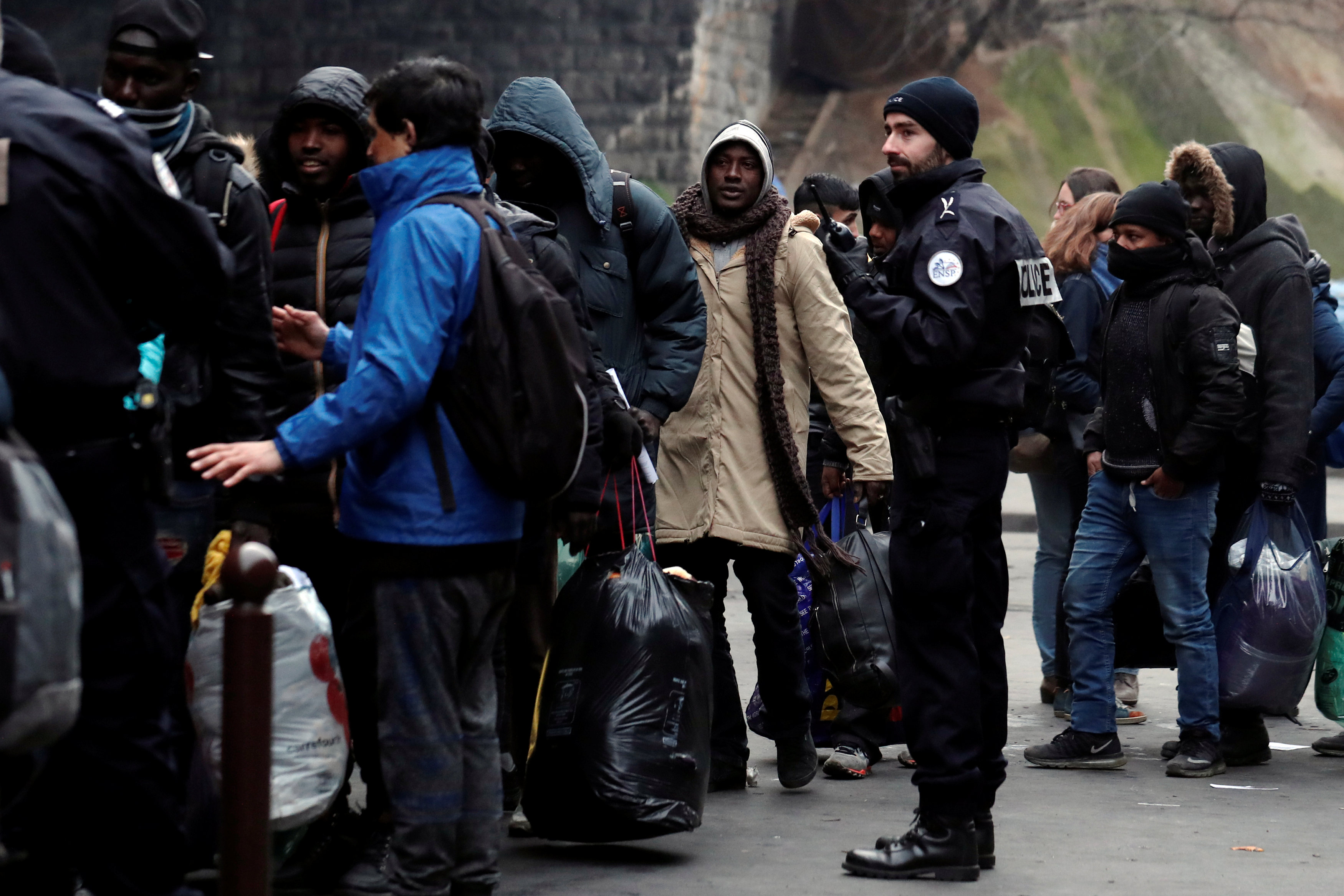 أحد أفراد الشرطة الفرنسية يتابع اللاجئين