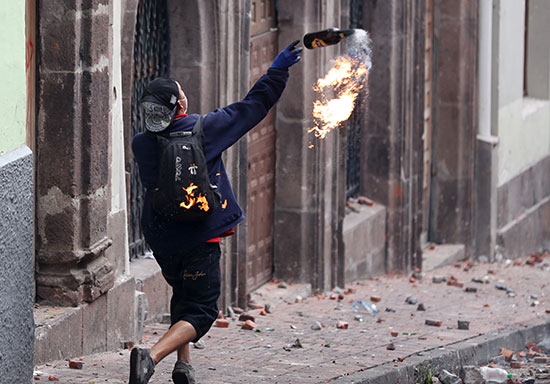 شاب يلقى زجاجة حارقة على قوات الأمن
