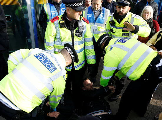 ضباط-الشرطة-يحتجزون-متظاهري-الانقراض-أثناء-مظاهرة-في-مطار-لندن-سيتي-2