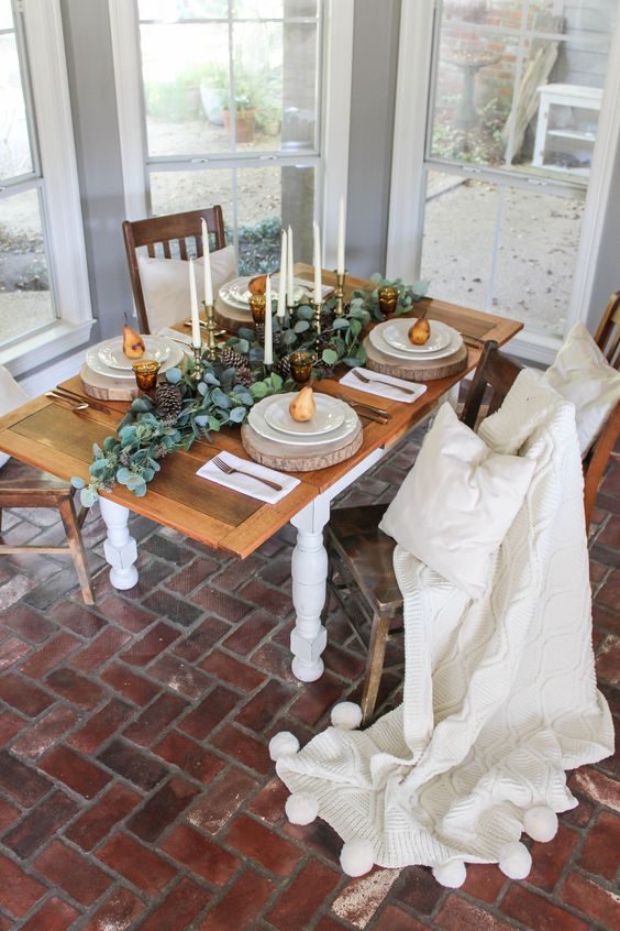 طاولة بسيطة مع الشموع الطويل القامة ، وشرائح الخشب والكمثرى في كل مكان