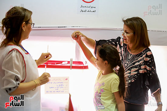طفلة تونسية تشارك والدتها أثناء الإدلاء بصوتها