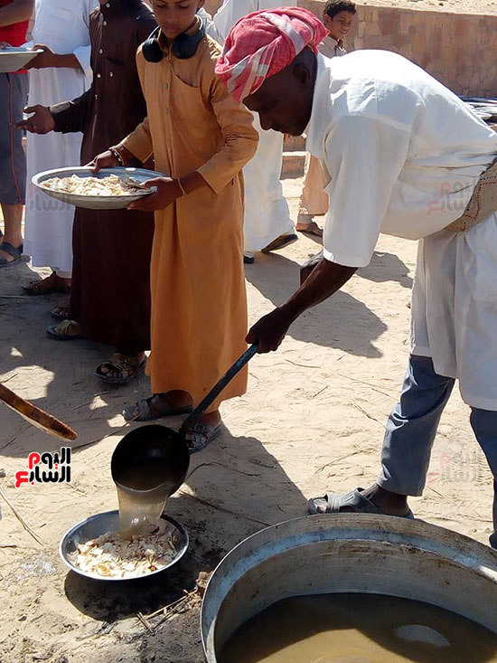 احد-الطباخين-يوزع-يغرف-الطعام-لتقديمه-للمشاركين