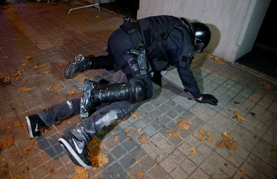 شرطى يعتقل أحد المتظاهرين