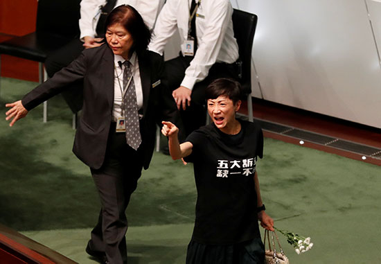 نائبة تصرخ بينما كاري لام الرئيس التنفيذي لهونج كونج تغادر المجلس التشريعي