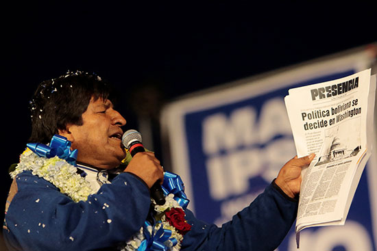 الرئيس البوليفي اليساري إيفو موراليس يمسك بصحيفة ويقرا منها أمام تجمع لانصاره