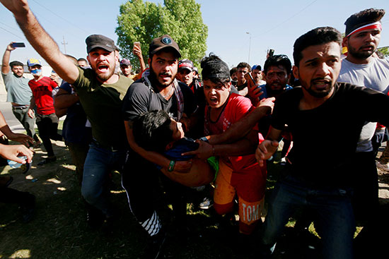 60463-رجال-يحملون-متظاهرًا-مصابًا-في-احتجاج-أثناء-حظر-التجول