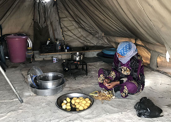 سيدة تطهى الطعام داخل الخيم