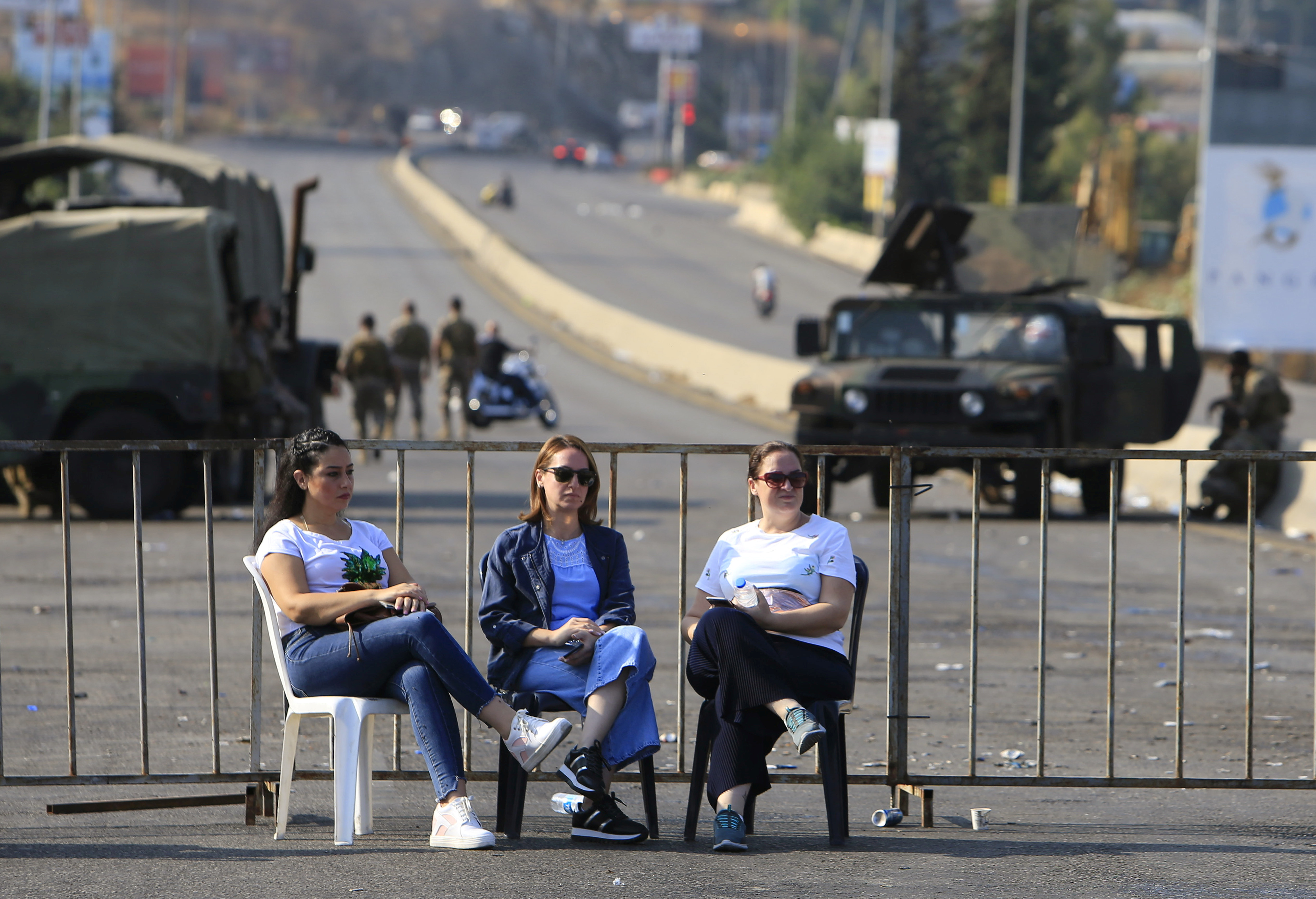 المتظاهرون يجلسون أمام حاجز يسد طريقًا رئيسيًا