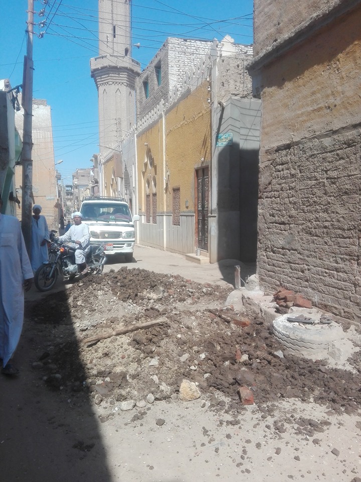 مدينة إسنا تجري أعمال رفع الجصات بشارع المنشية لتوصيل 150م صرف صحي لخدمة المواطنين (3)