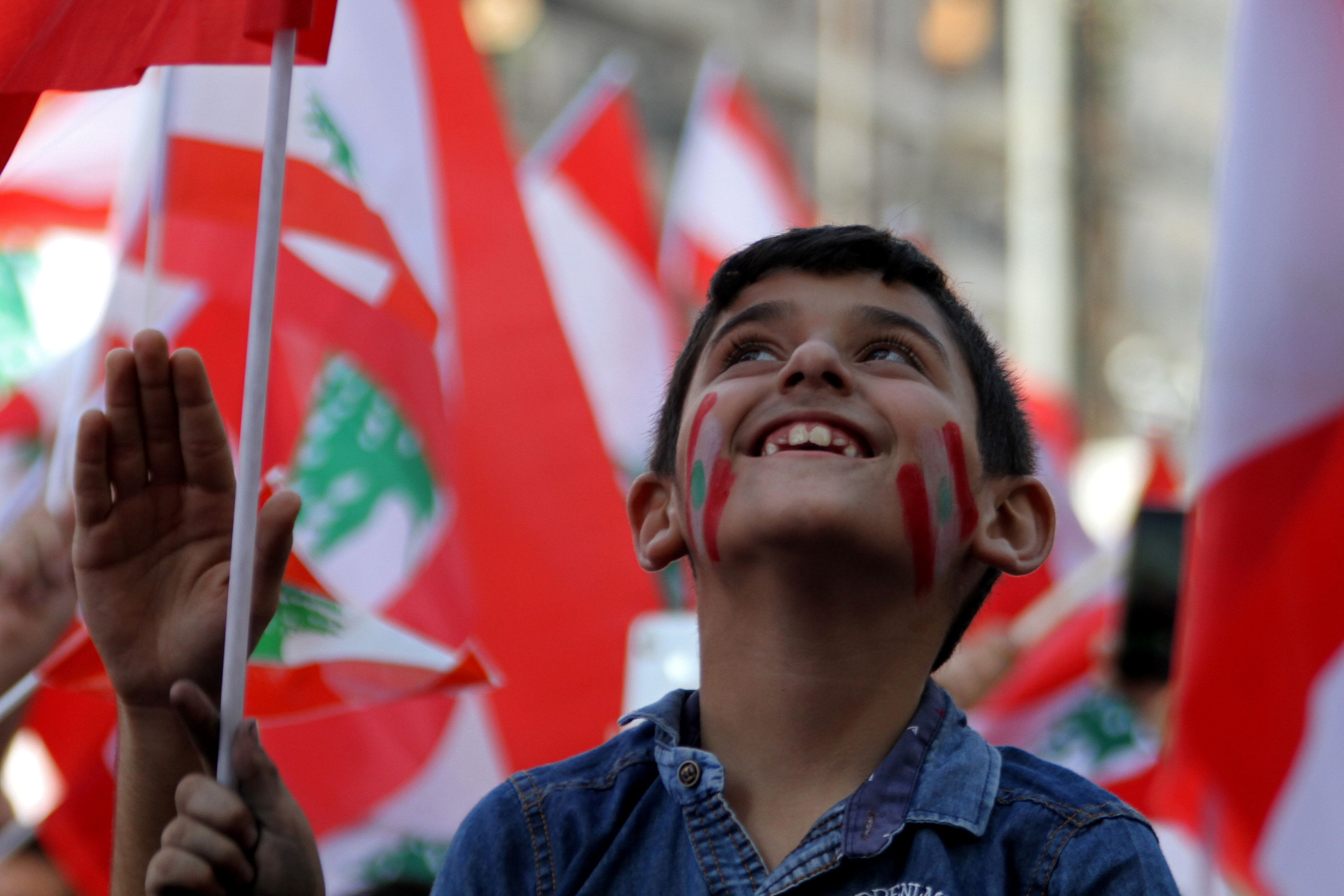 طفل يرسم العلم اللبنانى على وجهه فى مظاهرة بطرابلس