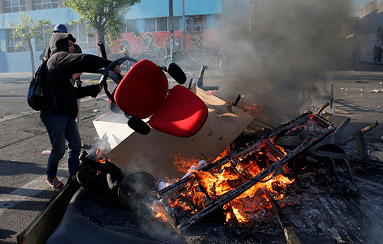 متظاهر يحرق كرسى فى تشيلى