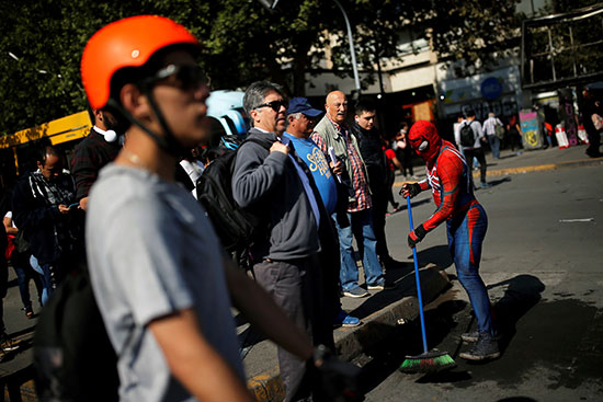 رجل يرتدى زى إسبايدر مان خلال تنظيف الشوارع