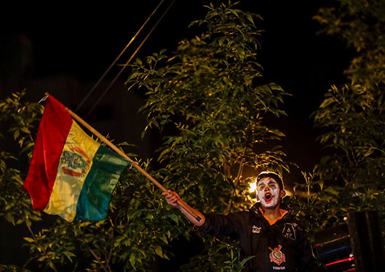 متظاهر يرفع علم بوليفيا