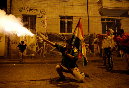 متظاهر-يحمل-علم-بلاده-بيد-وشمروخ-بيده-الأخرى