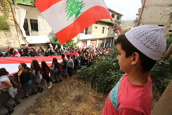 طفل-يرفع-العلم-اللبنانى-خلال-مسيرة-احتجاجية