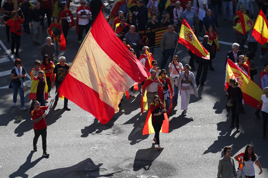 متظاهرون أسبان يحملون علم أسبانيا