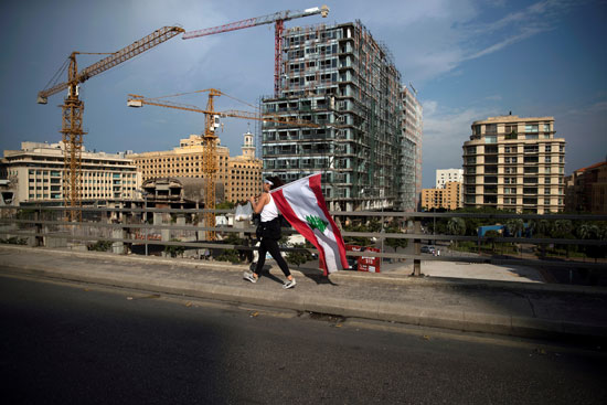 متظاهرة-تحمل-علم-لبنان