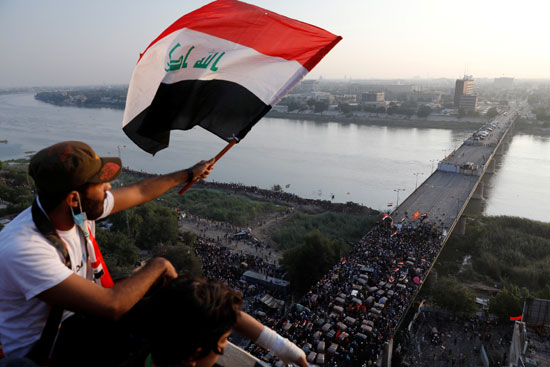 مواطنون يلوحون بأعلام العراق دعما للمسيرات