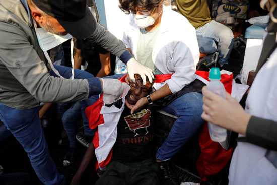 فرق طبية تحاول مداوة أحد المتظاهرين المصابين