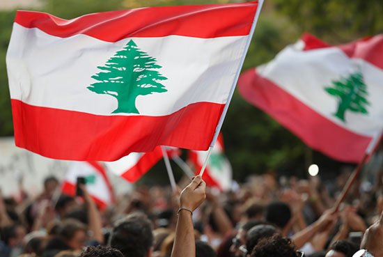 متظاهرون يرفعون أعلام لبنان