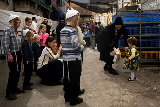 أطفال يشاهدون أثناء قيام سيدة يهودية متشددة بأداء طقوس كاباروت