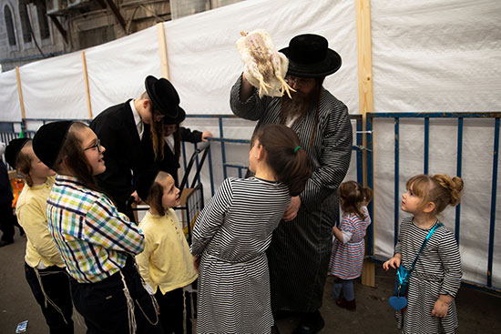 أطفال يشاهدون أثناء قيام رجل يهودي متشدد بأداء طقوس كاباروت