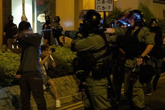ضابط شرطة مكافحة الشغب يستخدم رذاذ الفلفل تجاه متظاهر مناهض للحكومة