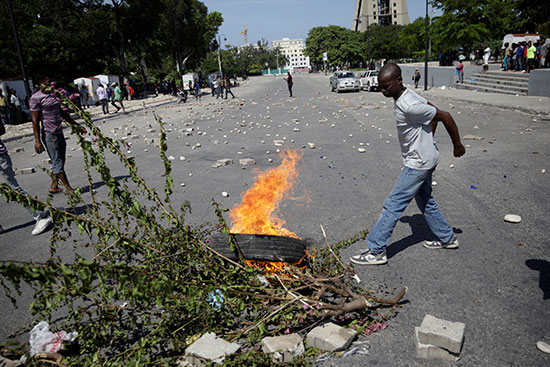أحد المحتجين يضيء إطارًا على النار في شارع الشان دي مارس