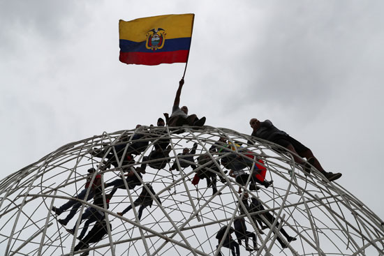 متظاهرون يرفعون علم الإكوادور