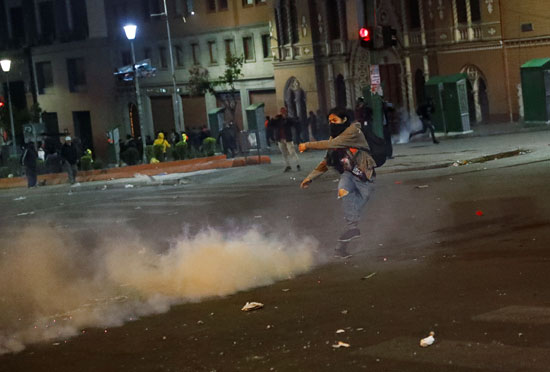 متظاهر يضرب قنبلة الغاز بالقدم