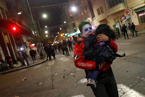متظاهر يهرب بطفلة جراء أعمال العنف